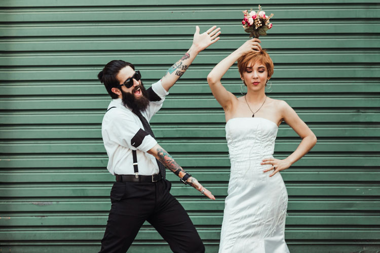 Hip bridal couple in front of a green wall